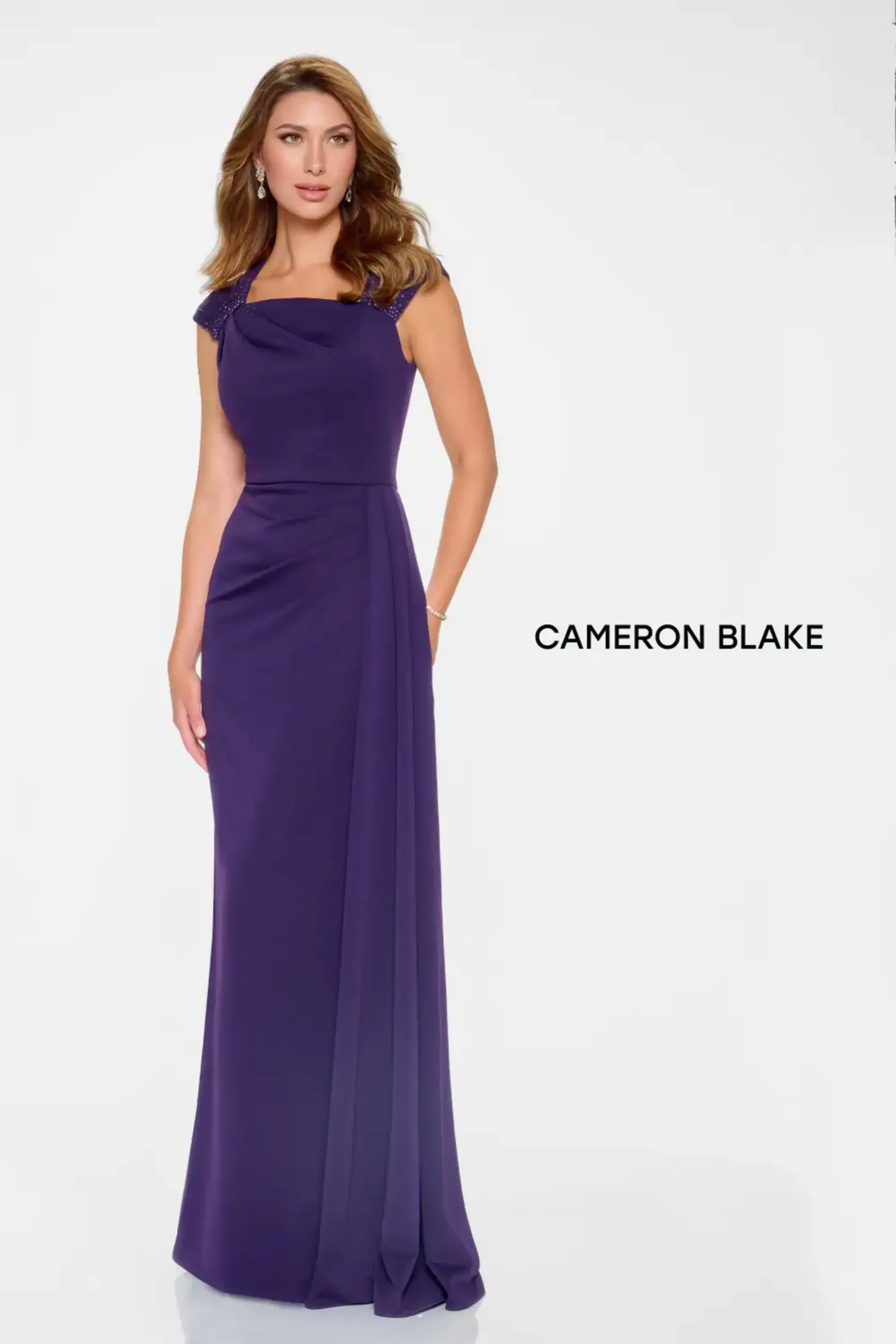 Model is wearing an evening gown with an asymmetrical neckline and cap sleeves made of stretch crepe