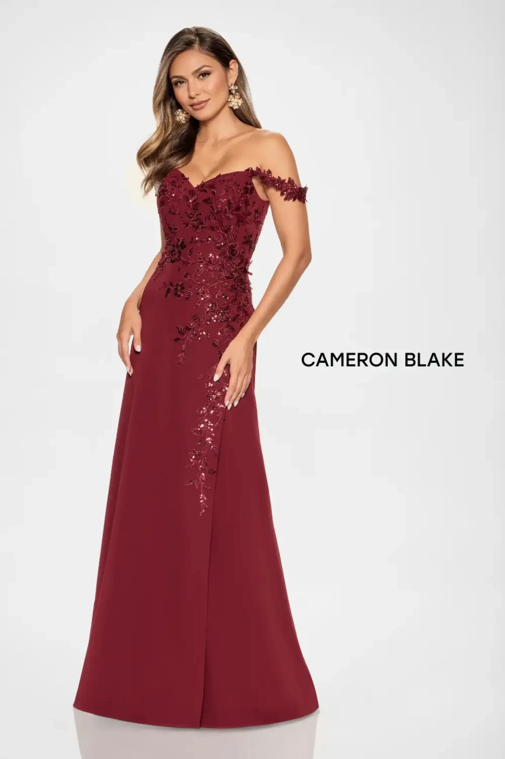 Model is wearing an a-line mother of the bride dress made of crepe and shimmery beads and sequins