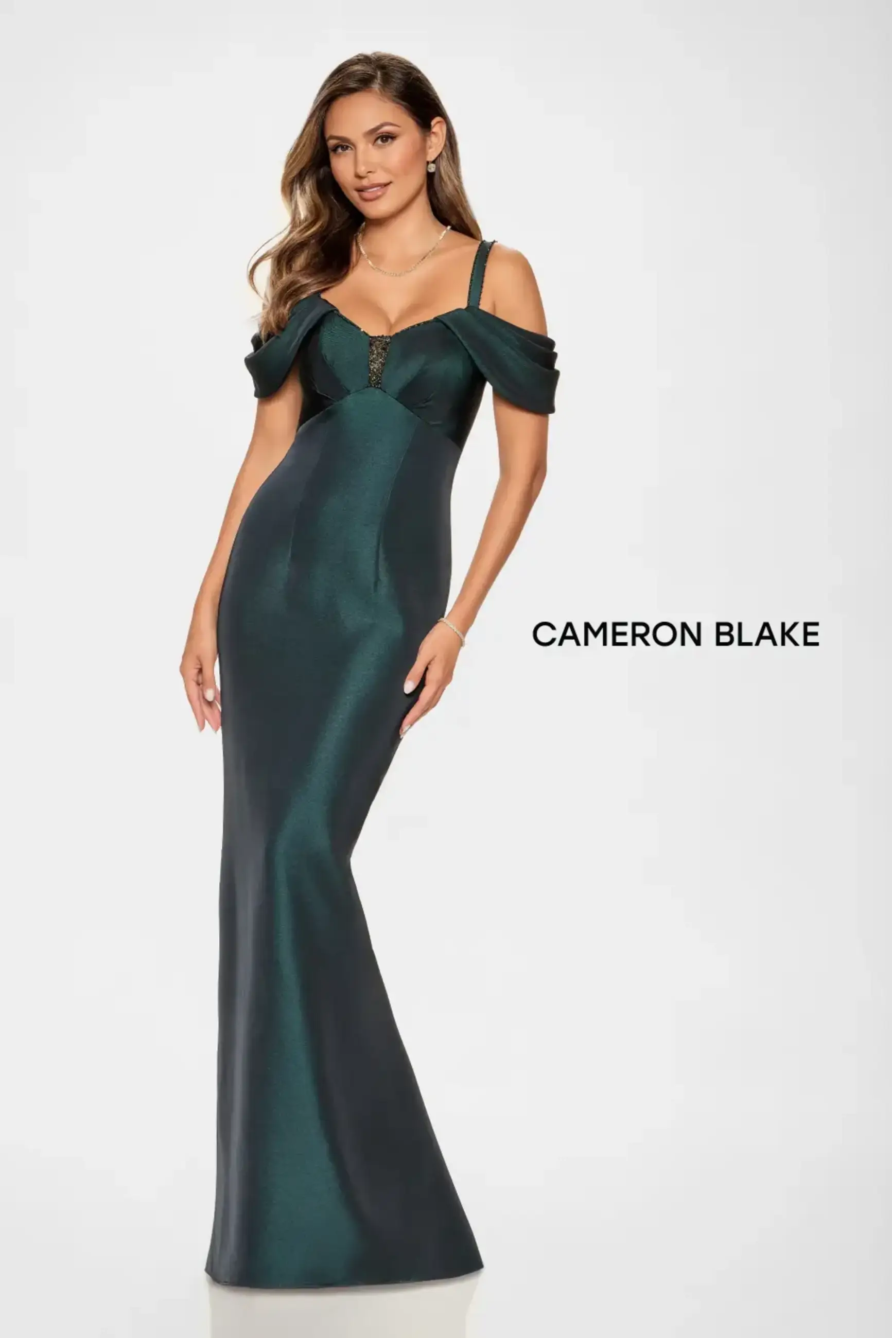 model is wearing an emerald green off the shoulder evening gown