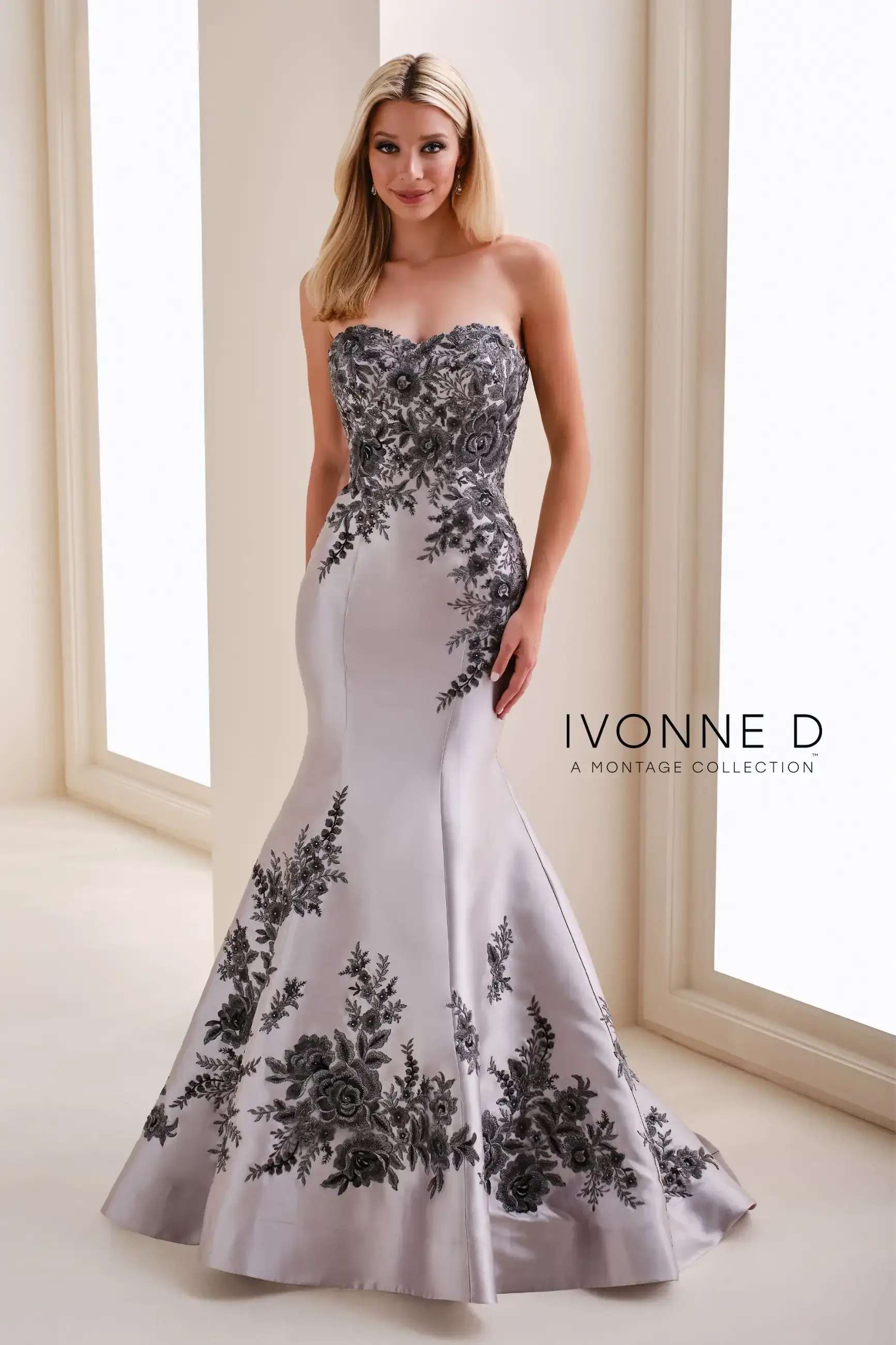 model is wearing a silver strapless mothers gown
