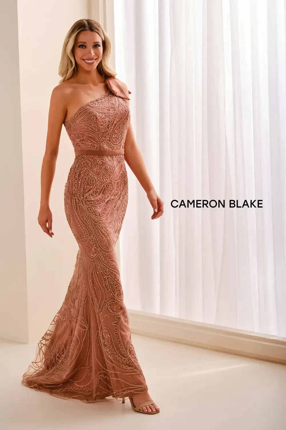model is wearing a one shoulder mother of the bride gown