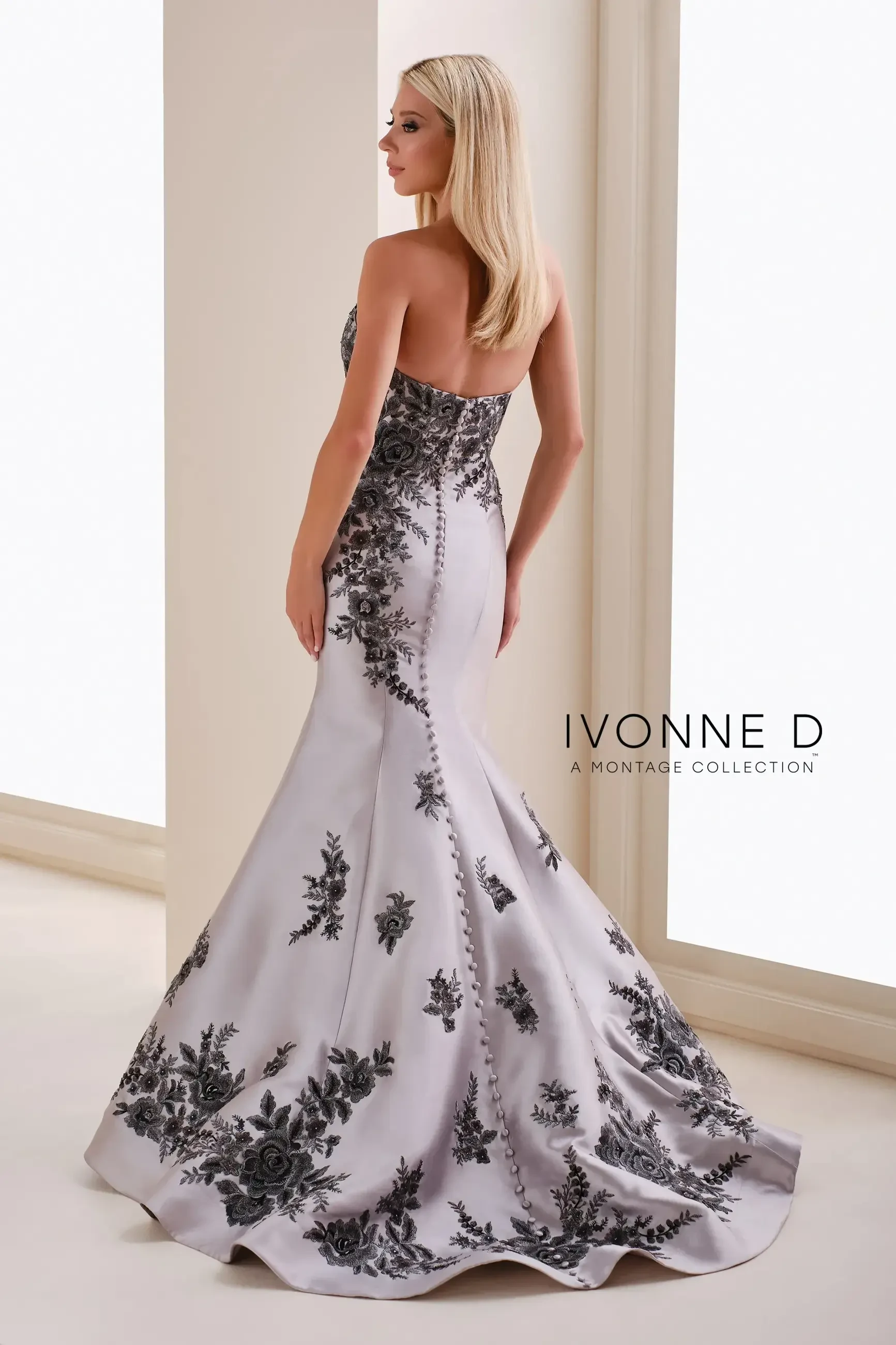 model is wearing a silver strapless mothers gown