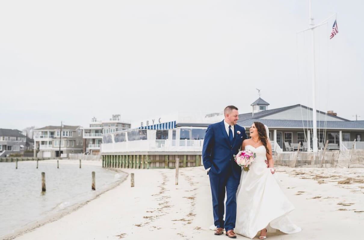 Bride and groom walking together on the beach