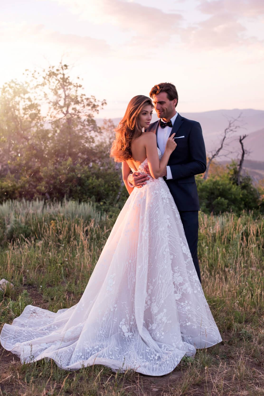Brunette bride and groom standing in field