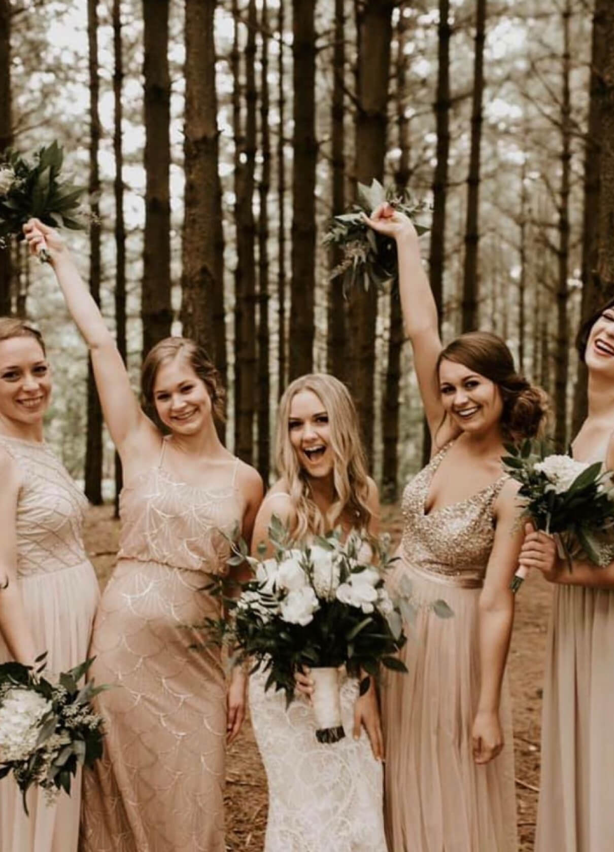 Bride holding floral bouquet with her bridesmaids