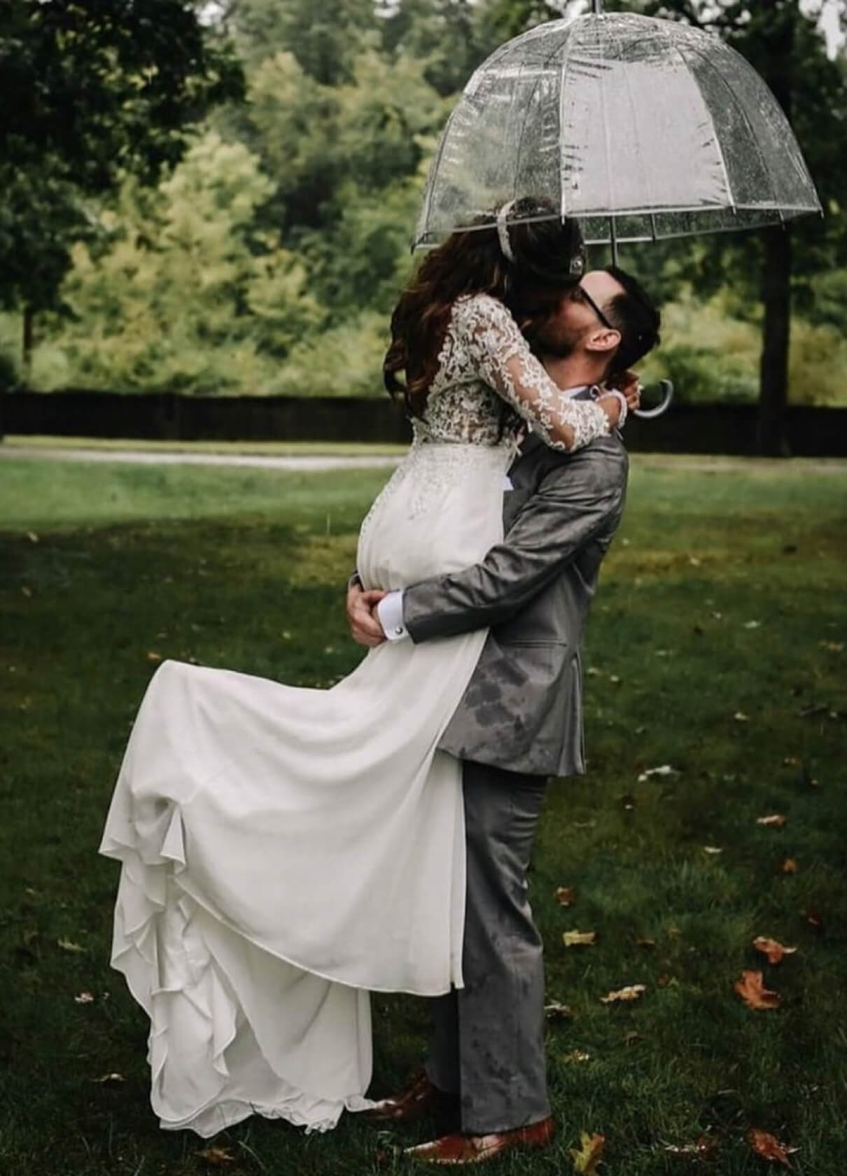 Bride and groom kissing in the rain