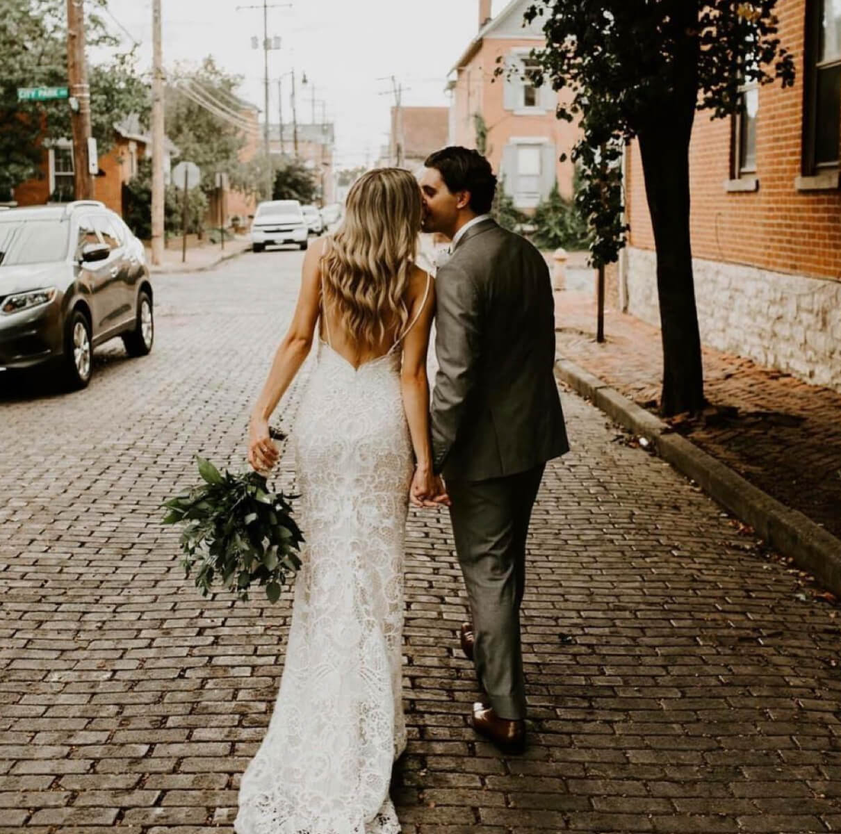 Bride and groom kissing in the street